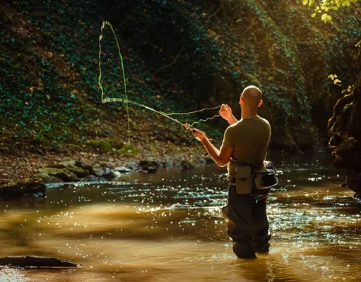 The Ultimate Guide to Fly Fishing Gear A fisherman fishing with fly fishing in the flowing stream