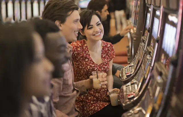 group of people playing the slot machines in a casino