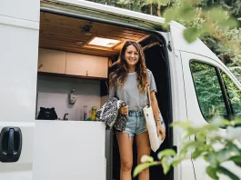 female in a van, smiling to the camera - van life concept