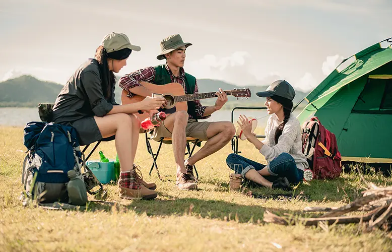 group of young people enjoy in music of drums and guitar on camping trip