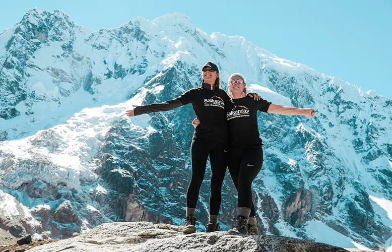 two women dressed in black standing on rocky mountain during daytime