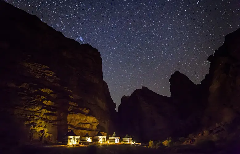 Tourist tents on the background of the starry sky. Wadi Rum Desert. Jordan.