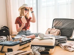 5 Things You Should Do To Prepare For Long-Term Travel Girl packing luggage in suitcases and travel documents