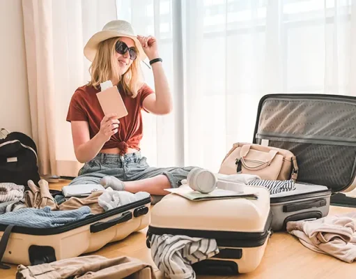 5 Things You Should Do To Prepare For Long-Term Travel Girl packing luggage in suitcases and travel documents