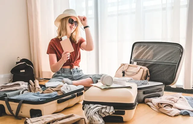 Girl packing luggage in suitcases and travel documents