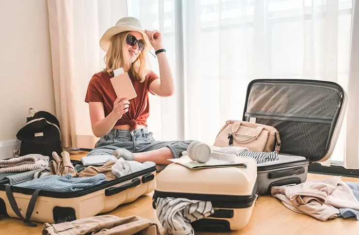 Girl packing luggage in suitcases and travel documents