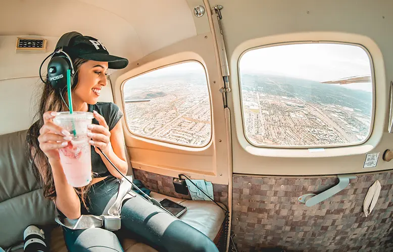 woman in blue denim jeans and black hat sitting on seat in a small aircraft