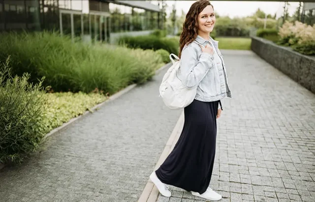 Happy pretty young brunette woman with backpack