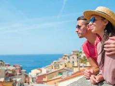 Cuisine, Culture, and Romance: Italy Honeymoon Package Highlights Man and woman with great view at old village Riomaggiore in honeymoon, Cinque Terre, Liguria, Italy
