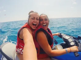 lesbian couple on vacation doing water sports on jet ski in ocean