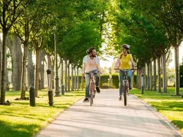 Young couple cycling bikes on sunny day