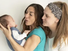 IR-4 Visa Application for Children Adopted in the U.S. A lesbian couple smiling at their baby, gay marriage, gay parents and adoption concept