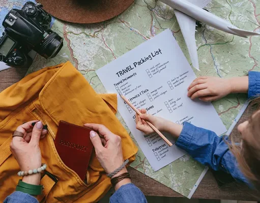 Travel essentials: The ultimate holiday checklist Little girl checking travel packing list while her mom putting passport into backpack.
