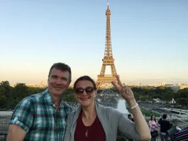 Mature couple traveling to Paris and taking selfie with Eiffel tower in background