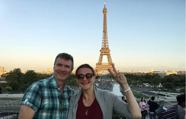 Mature couple traveling to Paris and taking selfie with Eiffel tower in background