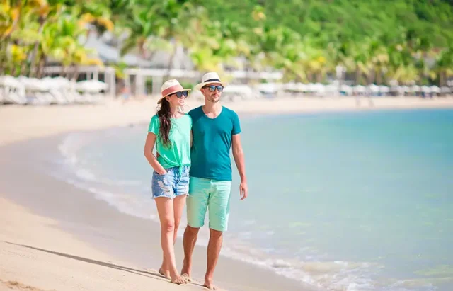 Young couple on white beach. Happy family on honeymoon vacation