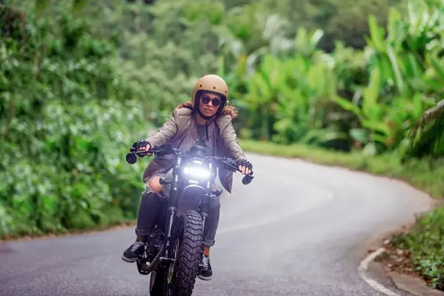 Female biker driving a cafe' racer motorbike