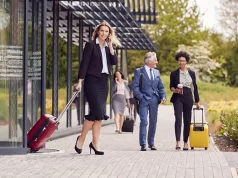 5 Mistakes to Avoid When Traveling for Business Group Of Business Delegates With Luggage Arriving At Conference Hotel