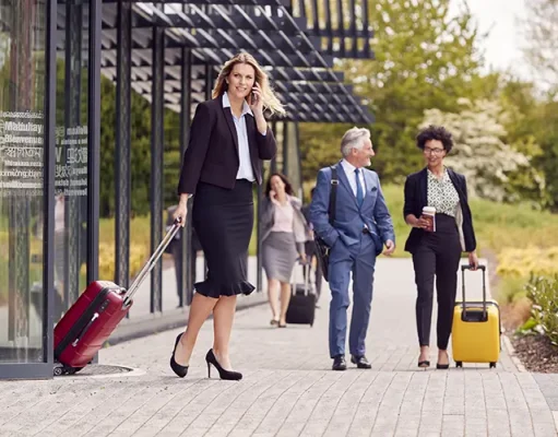 5 Mistakes to Avoid When Traveling for Business Group Of Business Delegates With Luggage Arriving At Conference Hotel