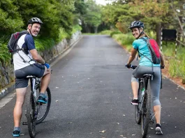 Smiling athletic couple cycling on the open road