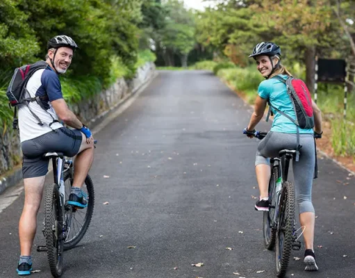 The Top Reasons To Start Cycling: Lifestyle and Health Benefits Smiling athletic couple cycling on the open road