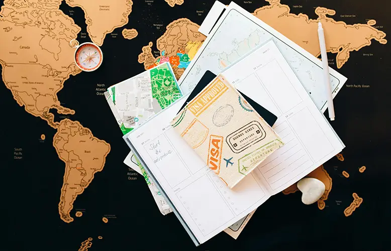 Passport on top of a map and a planner