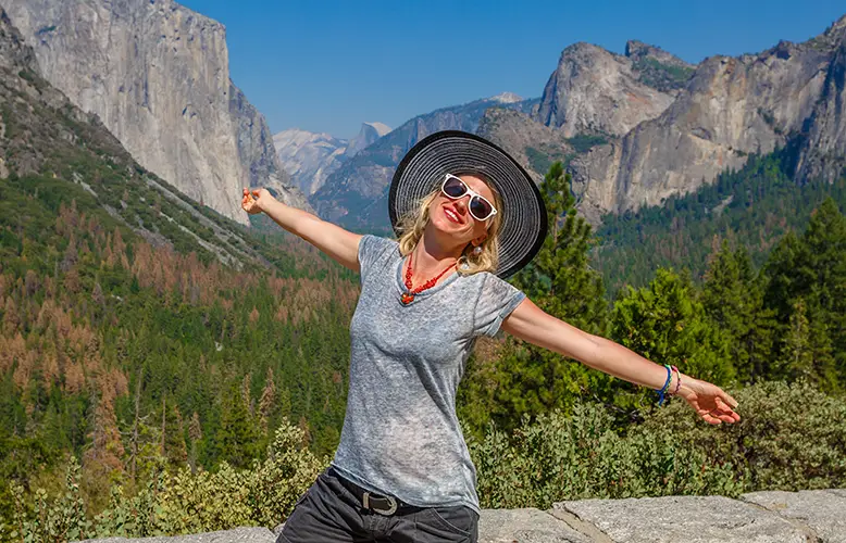 young-woman-with-arms-outstretched-standing-against-mountain-range copy