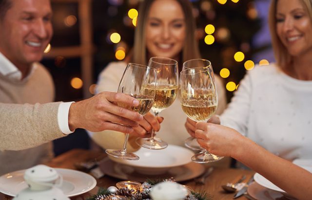 Friends celebrating christmas party holding wine Friends celebrating christmas party holding wine