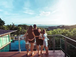Family in the terrace by the sea, watching the sunset.
