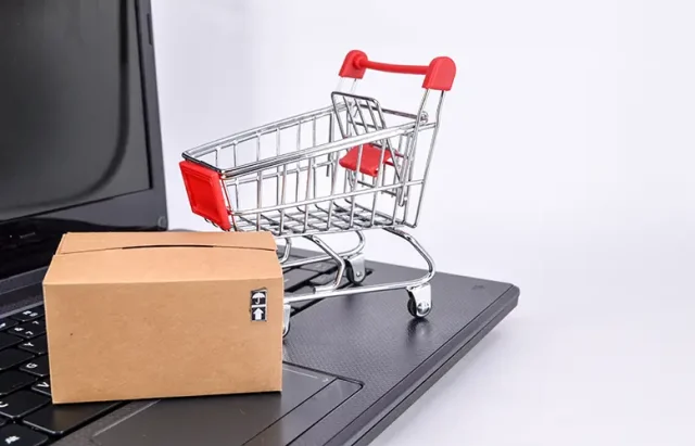 close-up-laptop-with-shopping-cart-cardboard-boxes-white-background copy
