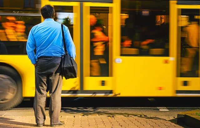 man-blue-shirt-bustle-city-against-passing-bus-man-near-road-view-from-back-tired-man-returns-from-office-work-work-routine-concept copy