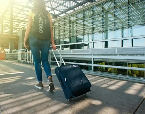 The Best Journeys Aren’t Always Scenic: Why Ugly Transit Days Make the Best Memories A woman carrying luggage
