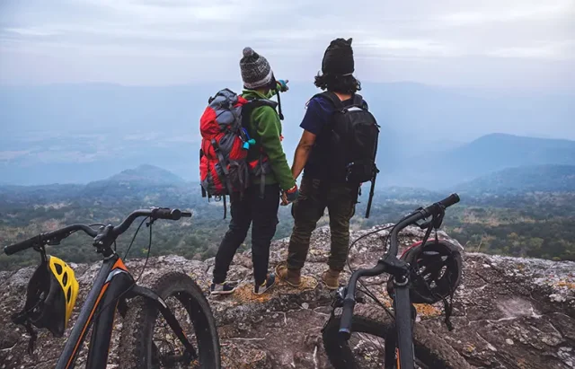 rear-view-people-with-bicycles-standing-mountain-against-sky copy