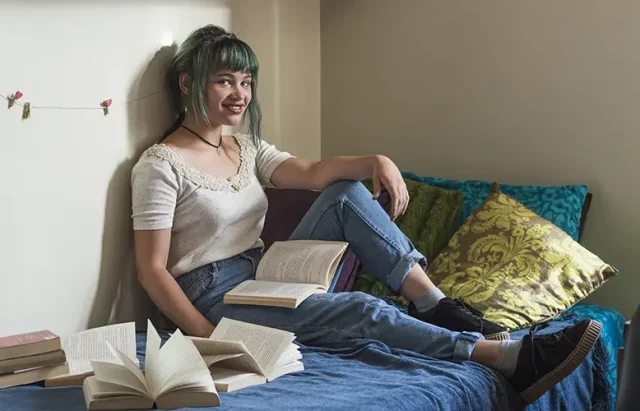 smiling-girl-studying-bed copy