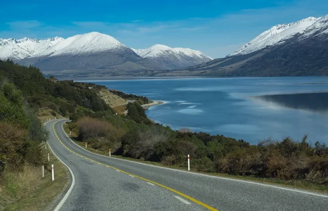 country-road-by-lake-against-snowcapped-mountains copy