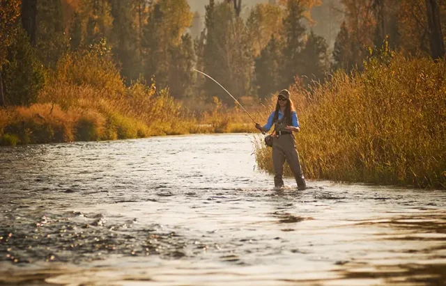 woman-fishing-river-against-plants-sunset copy