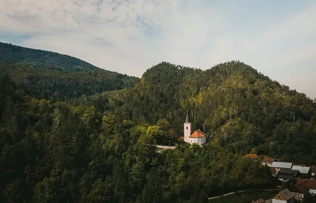 aerial-of-a-church-and-a-tower-surrounded-by-a-den-2025-02-11-21-13-50-utc copy