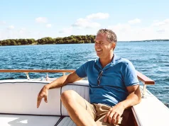 Boat Ownership vs. Club Access: The Busy Leader’s Choice Smiling man relaxing on a boat in Florida waters, enjoying hassle-free boating without ownership on a sunny day.