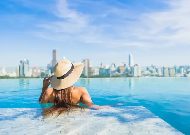 portrait-beautiful-young-asian-woman-relaxing-around-outdoor-swimming-pool-with-city-view copy