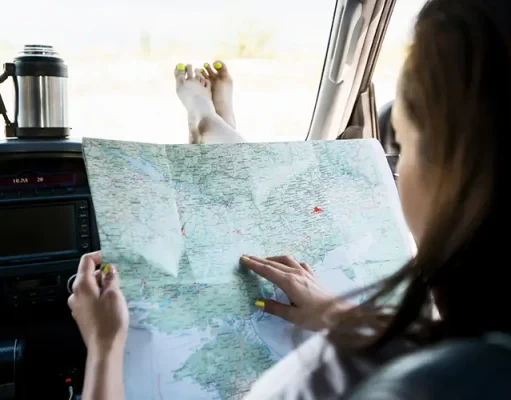 Ways to Maximize Your Experience When Traveling on a Budget a woman holding a map in the car