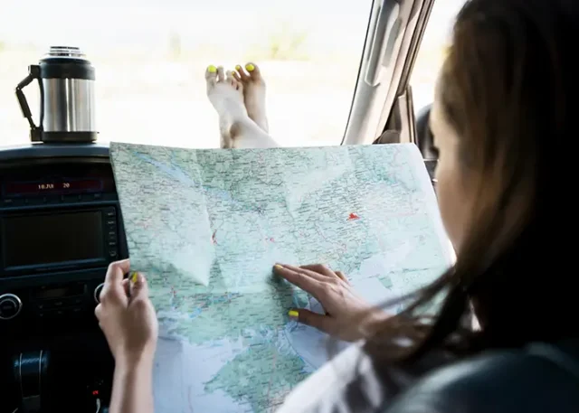 a woman holding a map in the car