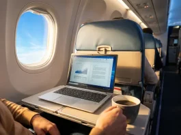 Person working on a reliable laptop with coffee in airplane