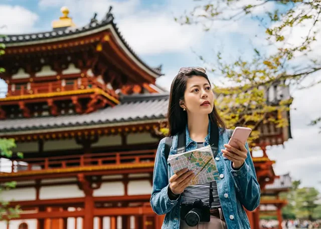 asian-tourist-using-smartphone-map-search-sightseeing-spot-byodo-temple-background-with-blue-sky-travel-lens-man-chatting-by-mobile-phone-communication-app-travel copy