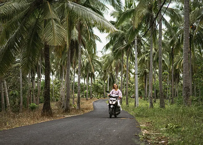 young-woman-driving-moped-tropical-life copy