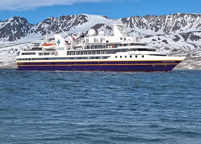 Heritage Discoverer expedition ship sailing through a remote polar landscape