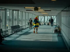 The First Ten Minutes: Why Connectivity Now Defines a Seamless Arrival a man walking down a long airport hallway with lots of windows