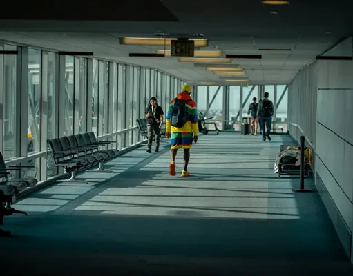 The First Ten Minutes: Why Connectivity Now Defines a Seamless Arrival a man walking down a long airport hallway with lots of windows
