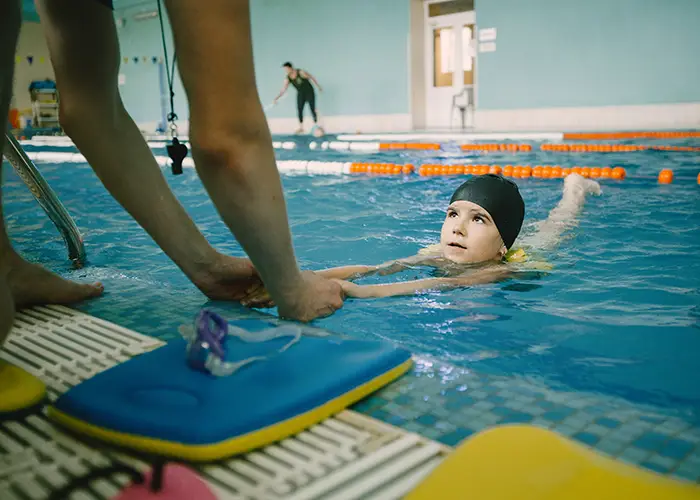 coach-teaching-kid-indoor-swimming-pool-how-swim-dive-swimming-lesson-kids-development copy