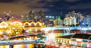 How Singapore Became One of Southeast Asia’s Best Cities for Japanese Food The Singapore River glowing lights at night with the city skyline illuminated in the background.