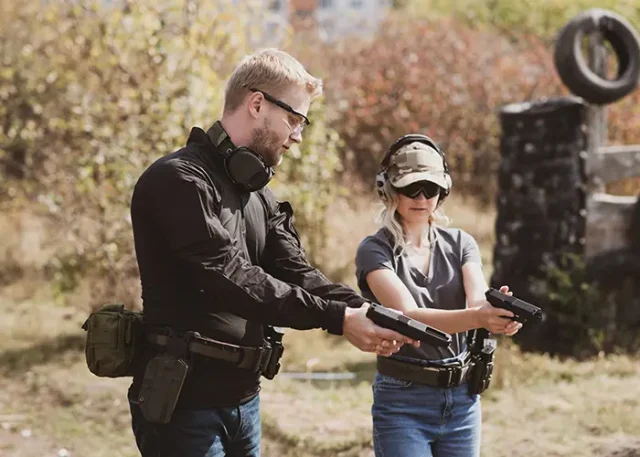 woman-learns-shoot-pistol-shooting-range-with-instructor copy